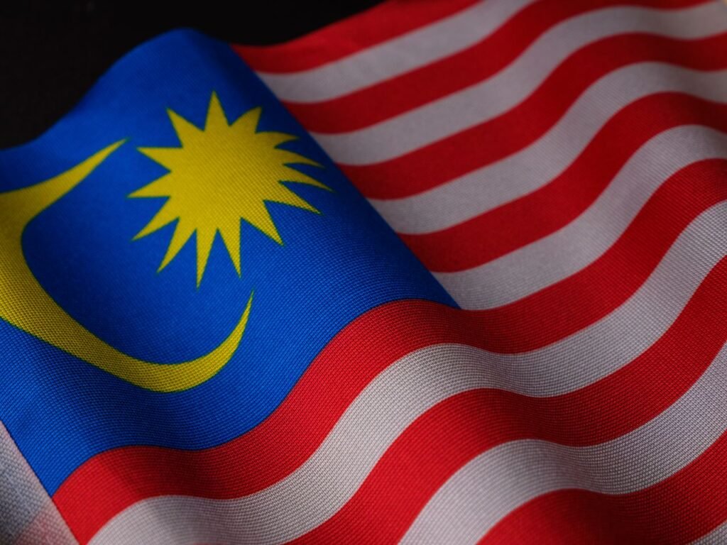A detailed close-up of the Malaysian flag showing its vibrant colors and waving fabric texture.